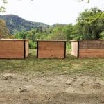 Photo de 3 composteurs partagés en bois installés sur une pelouse