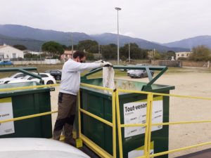 Personne en train de déposer des déchets dans une benne de tout-venant.