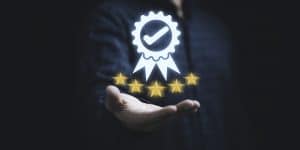 Main avec au-dessus un symbole de label et des étoiles dorées