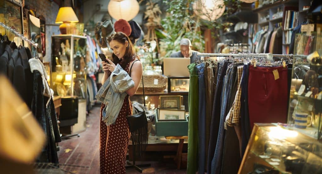 Personnage dans une boutique de seconde main avec vêtements et objets de décoration